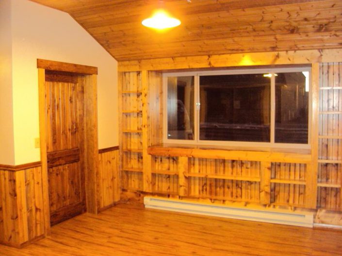 custom shelving with pine door, ceiling, and floating laminate floor
